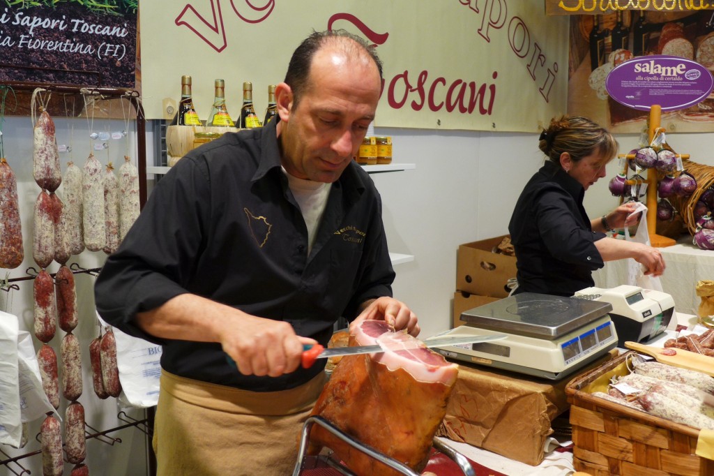A Tuscan prosciutto producer slicing the air-cured ham with a razor-sharp knife by hand at the artisans expo in Florence. Credit: Nathan Hoyt